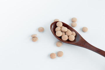 Herbal pills in wooden spoon, Natural herbs, Alternative Medicine, Herbal supplement