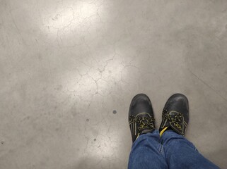 maintenance mechanic in work shoes. Gray background. Copy space.