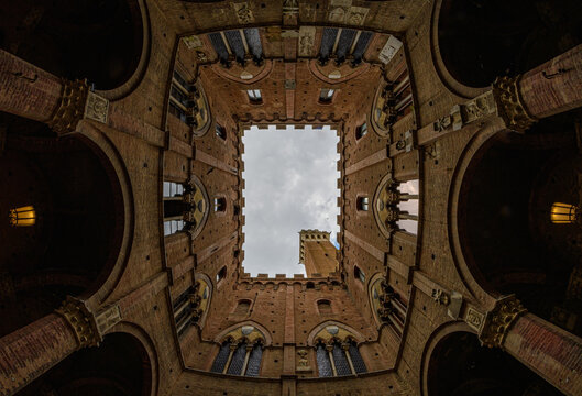 fisheye view through a building of a tower in siena italy