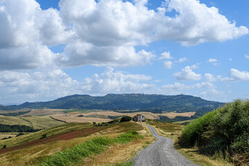 road in the hills in tuscany italy to a old house