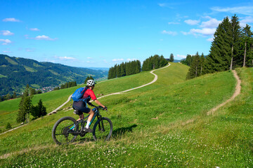 Obraz premium nice active senior woman riding her electric mountain bike at Mount Huendle in Oberstaufen, Allgaeu Alps , Bavaria, Germany