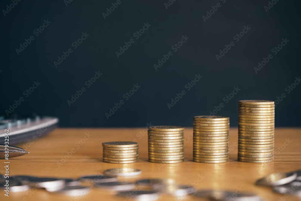 Wall mural golden money coin stack on black background. symbolizing wealth, success, and financial growth. fina