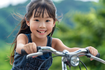 Obraz premium Happy young girl riding bicycle in nature