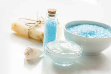 blue set for bath with salt and shells on white table background