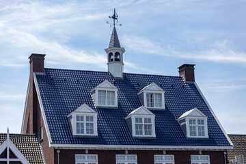 Architectural detail of typical Dutch bright colored deep blue rooftop with window panes