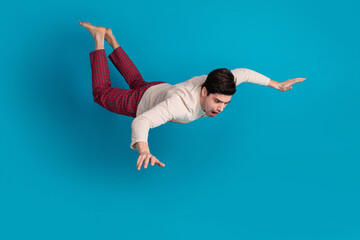 Full length photo of handsome young guy falling down nervous dressed sleepwear sleepover good morning isolated on blue color background