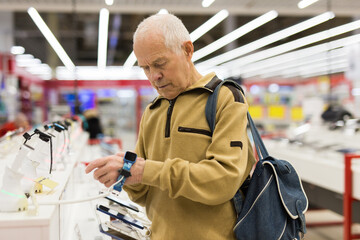 Pensioner buys a modern watch in the showroom of a digital electronic goods store