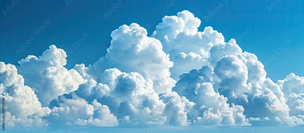 Wall mural puffy white clouds floating in a clear blue sky with ample copy space image