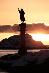 Silhouette of Statue at Sunset on Rocky Coast
