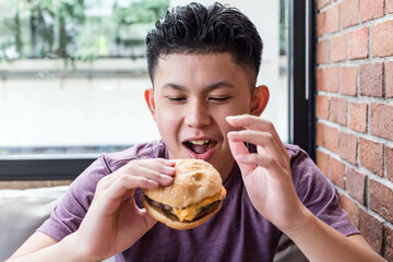 boy eating hamburger.