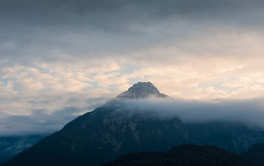 Alps mountain top in fog cloud. Travel lifestyle copy space background, austria landscape