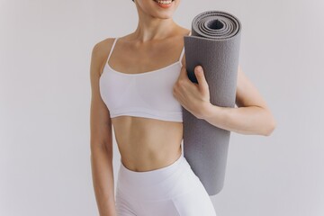 Сropped close-up photo of young woman holding yoga mat isolated on white background, panoramic...