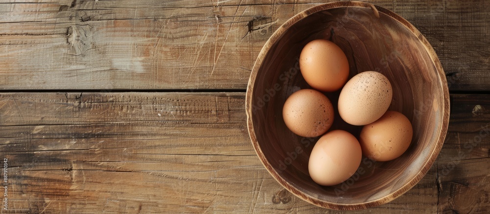 Sticker Wooden table hosting a wooden bowl with four eggs perfect for a copy space image