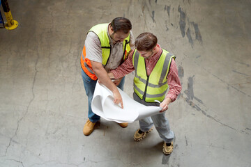Warehouse workers or engineers team discuss and review a morning brief together.