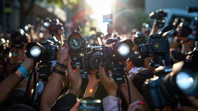 Large crowd of photographers holding up cameras, capturing an event with bright flashes in an outdoor setting.