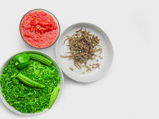 small fried fish with tomato sauce and vegetables  on white background