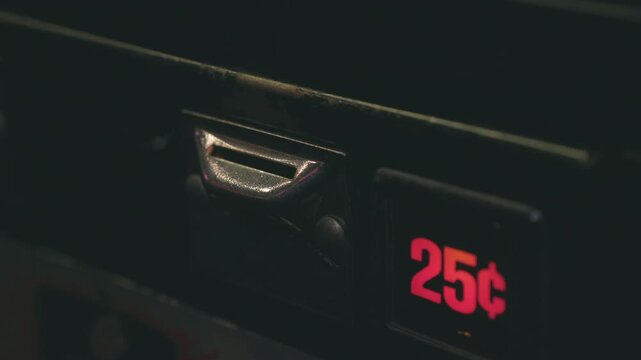 Old school arcade machine quarter inserted into slot 4k
