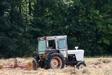 Raking and Baling Hay in summer with tractor and attachments