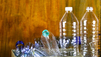 Waste plastic bottles on wooden background waiting for recycling concept of saving our environment sustainable natural resources.