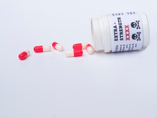 Medication capsules next to white bottle on a white background with copy space