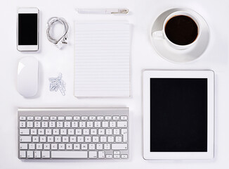 Instruments of productivity. A high angle view of various office equipment items and digital devices.