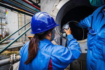 Worker female hand holding gas detector inspection safety gas testing at front manhole tank...