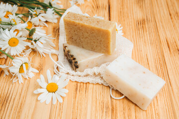 Handmade soap from natural ingredients, various herbs, chamomile. Concept of sustainable use, bath products on a wooden background. Top view