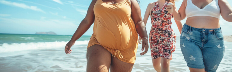 Fototapeta premium Three women are walking on the beach, one of them is wearing a yellow dress
