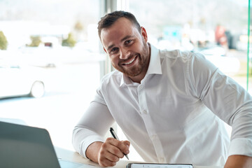 Man, paperwork and portrait in office at car dealership with contract, sales and discount for...