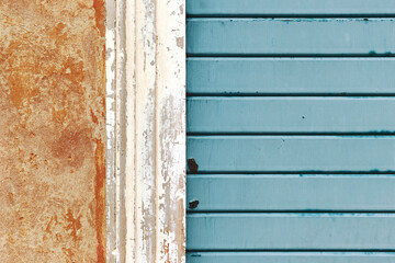 Detail of wall and blue garage door, dirty background