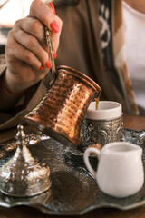 A woman pours traditional Turkish coffee