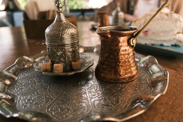 Traditional Turkish coffee with milk and sweets on a metal tray