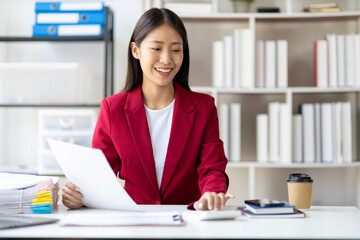 Businesswoman working with documents is analyzing financial data statistically, calculating income and expenses, managing budgets and planning finances.