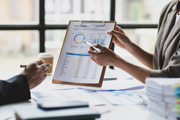Coworkers are discussing company growth charts and graphs during a budget meeting. Business adviser meeting to discuss the situation on the financial report. Accounting, investment and marketing plan.