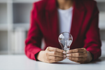 Businesswoman hand holding light bulb and idea.