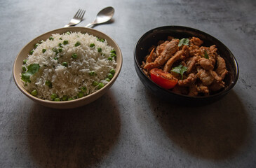 Indian food rice and chicken served in bowls. Close up, selective focus.