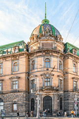 Lviv, Ukraine - November 2, 2023: Vertical view of the intersection of Svobody Avenue and Akademika Hnatyuka Street in Lviv. People walk past the ancient building of the former Galician Savings Bank