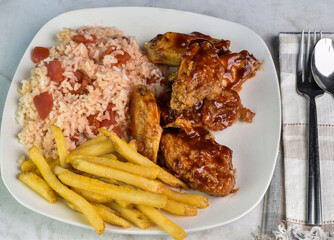 chicken wings  with  rice and tomatoes served wth fries