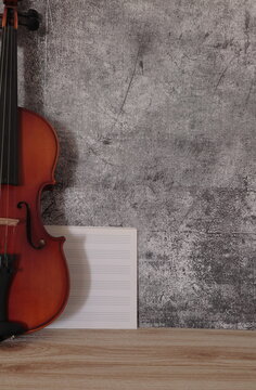 violin apooyado fondo gris negro partituras blanco 