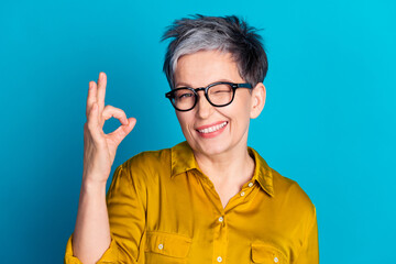 Photo of pretty cheerful woman wear blouse spectacles winking eye showing okey sign emtpy space...