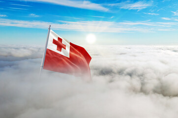 Tonga flag aerial view in beautiful sky with clouds. Top-down drone shot at sunrise or sunset. Aerial bird's eye view of the flag with cloudscape.