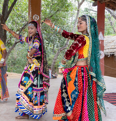 young indian girls performing traditional folk dance in rajasthani attire from different angle