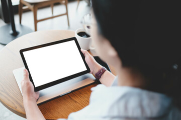A woman hand showing digital tablet blank screen on work desk in cafe.