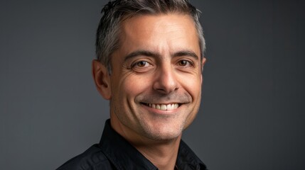 Fototapeta premium Confident businessman with short dark hair smiles in a casual headshot portrait