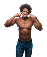 Fototapeta premium Afro american shirtless man showing nude body over isolated background covering ears with fingers with annoyed expression for the noise of loud music. Deaf concept.