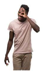 Young african american man with happy face smiling doing ok sign with hand on eye looking through fingers