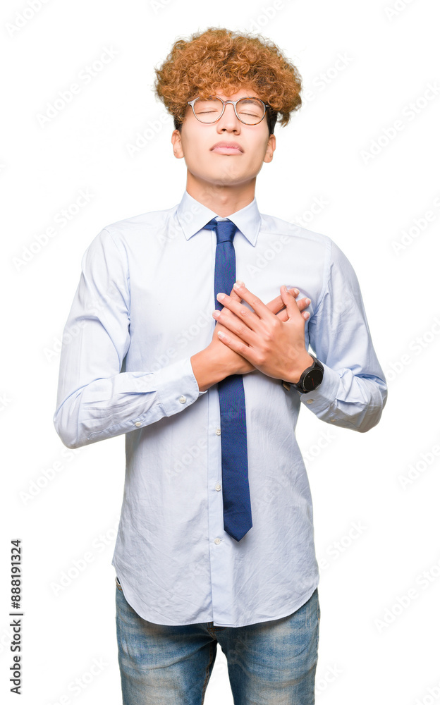 Wall mural young handsome business man with afro wearing glasses smiling with hands on chest with closed eyes a