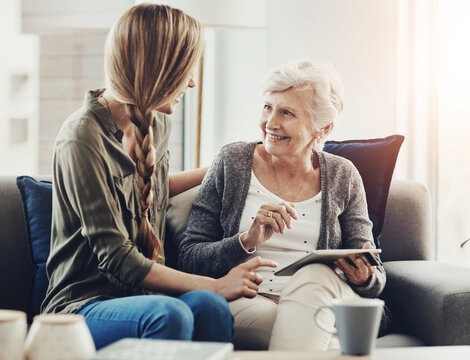 Tablet, sofa and woman with senior mother in home for help with online blog, internet or connectivity. Bonding, teaching and elderly female person learning digital technology with daughter at house.