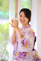 Japanese woman smile with yukata dress and milk tea in hand