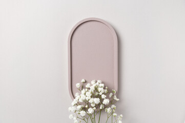 Beauty product presentation scene made with delicate white flowers against a soft beige oval backdrop highlights your brand's minimalist style. Perfect for cosmetics, skincare, or luxury items.